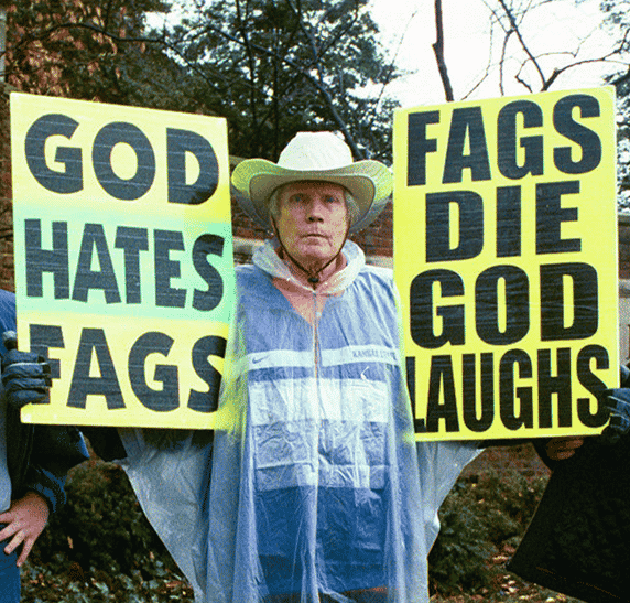 Man holding two anti-gay signs in protest